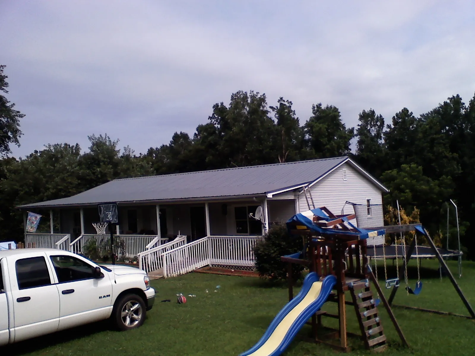 Dark metal roof on a country home with a full length front porch in Hastings